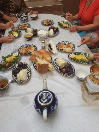 a table full of plates of food on a table at Madina-Mehribon Welcome to Bukhara in Bukhara