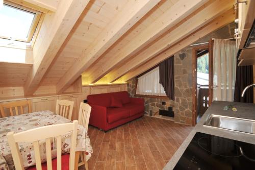 a living room with a red couch and a table at Casa Viola in Valdidentro