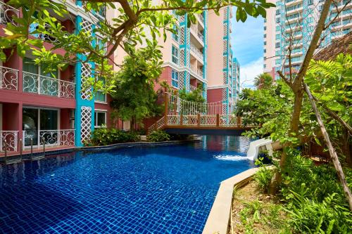 a swimming pool in front of a building at Grande Carribean sea view apartments Jomtien beach in Pattaya South