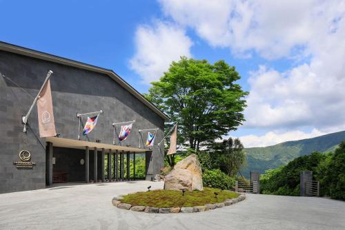 a building with flags and a rock in front of it at THE HIRAMATSU HOTELS & RESORTS SENGOKUHARA HAKONE in Hakone