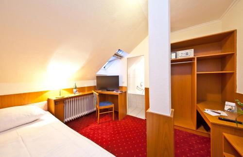 a hotel room with a bed and a desk with a computer at Hotel Primus Frankfurt Sachsenhausen in Frankfurt/Main