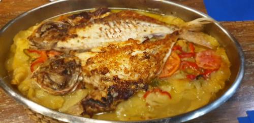 a metal bowl of food with fish and vegetables at Hotel Alfar in Isla