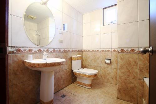 a bathroom with a sink and a toilet and a mirror at Hua Du Hotel in Keelung
