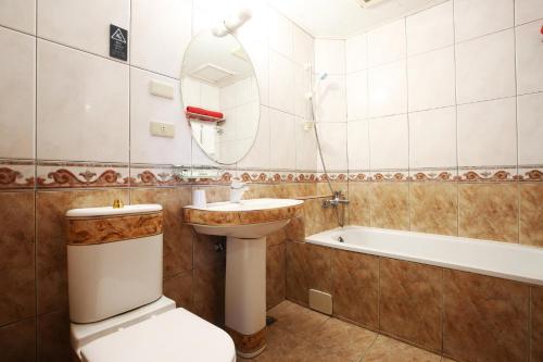 a bathroom with a sink and a toilet and a tub at Hua Du Hotel in Keelung