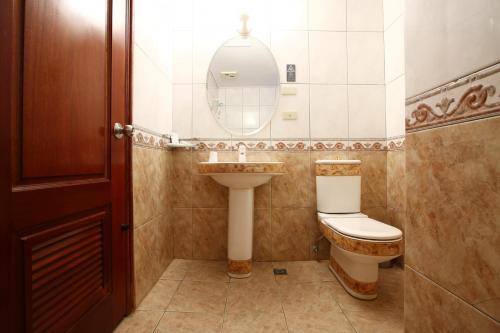 a bathroom with a toilet and a sink and a mirror at Hua Du Hotel in Keelung
