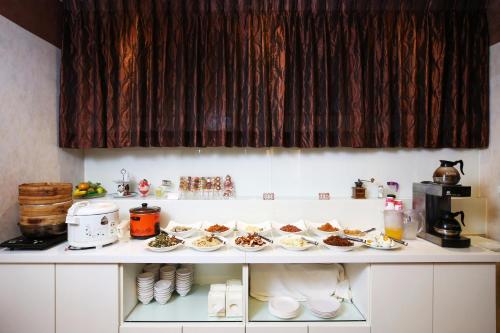 a table with plates of food on a counter at Hua Du Hotel in Keelung