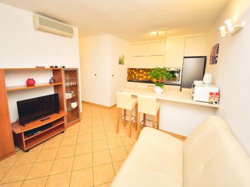 ein Wohnzimmer mit einem Sofa und eine Küche mit einem Tisch in der Unterkunft Apartment Anica-1 by Interhome in Zadar