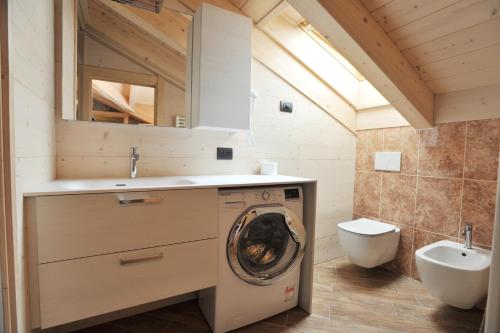 a bathroom with a washing machine and a toilet at Casa Viola in Valdidentro