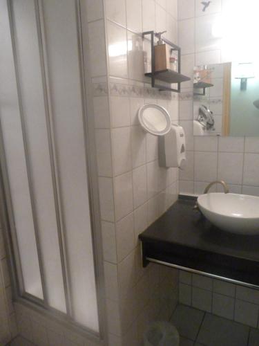 a white bathroom with a sink and a mirror at Domaine Des Hauts Viaux in La Bresse