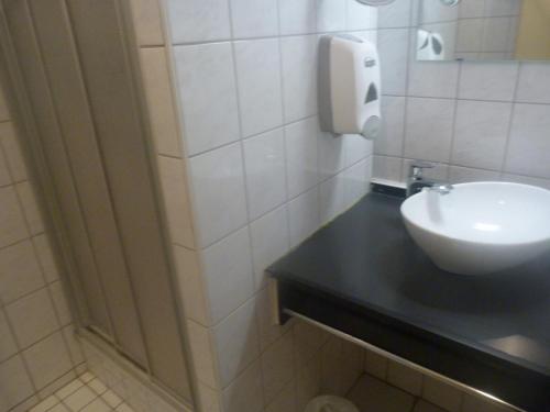 a bathroom with a sink and a soap dispenser on the wall at Domaine Des Hauts Viaux in La Bresse