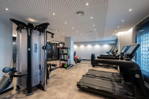 a gym with treadmills and elliptical machines at Catalonia Barcelona Plaza in Barcelona