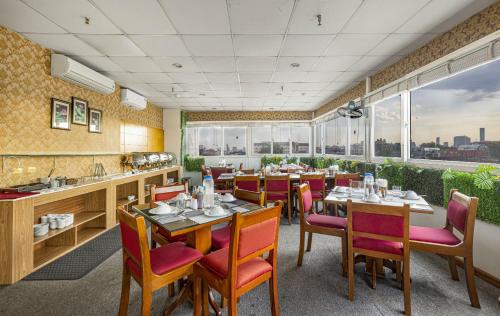 a restaurant with tables and chairs and windows at First Eden Hotel - Hang Bun in Hanoi
