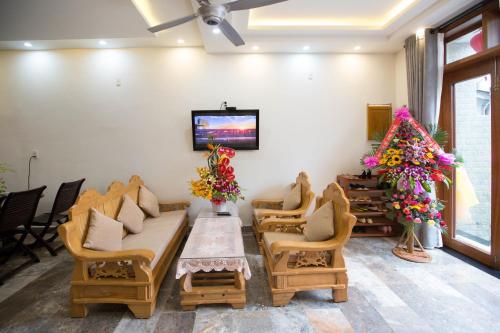 a waiting room with chairs and a table and a tv at Lan Uyen Homestay - Hoi An in Hoi An