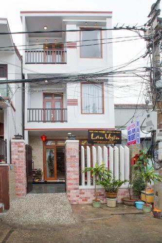 a large white building with a store in front of it at Lan Uyen Homestay - Hoi An in Hoi An
