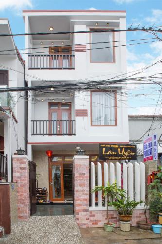 a white building with a sign in front of it at Lan Uyen Homestay - Hoi An in Hoi An