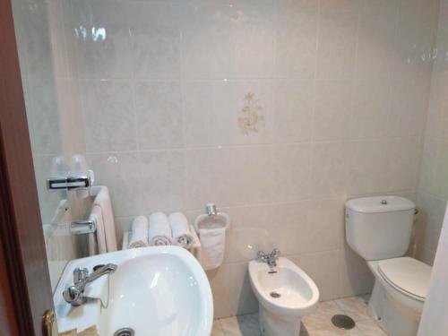 a bathroom with a sink and a toilet at Hostal Mourelos in O Grove