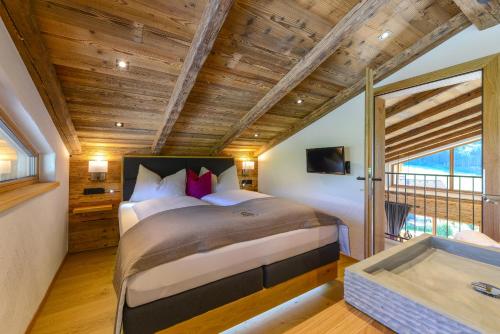 a bedroom with a large bed and a tub at Gams Lodge in Goldegg