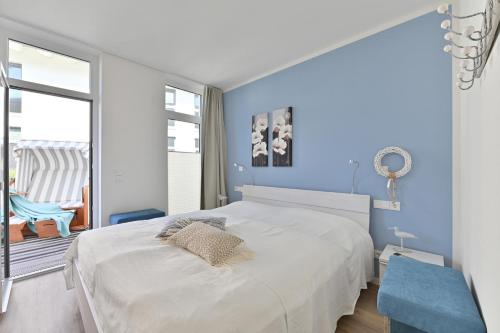 グロヴェにあるFerienwohnung Trauminselのベッドルーム1室(白いベッド1台、青い壁付)