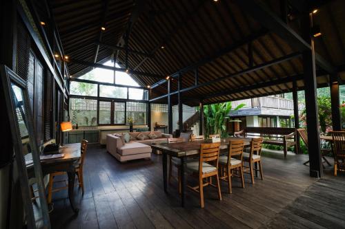 a living room with a couch and a table and chairs at Surya Kembar Villas in Ubud
