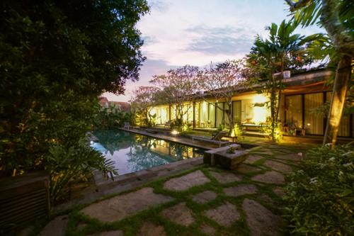 a house with a pool in the middle of a yard at Surya Kembar Villas in Ubud