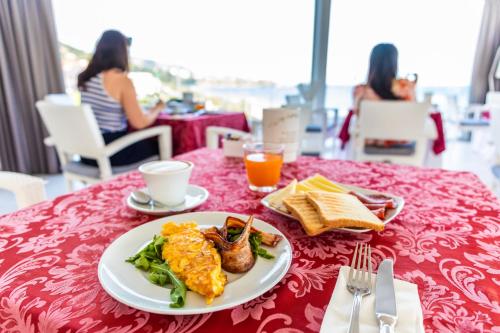 a table with a plate of food on a red table cloth at Victoria Palace Cefalù in Cefalù