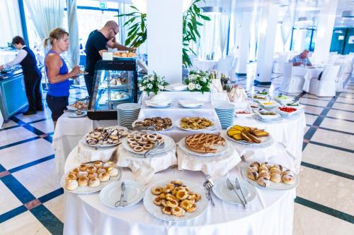 a long table with plates of food on it at Cefalù Sea Palace in Cefalù