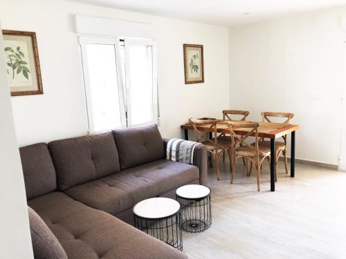ein Wohnzimmer mit einem Sofa und einem Tisch in der Unterkunft Apartamentos Lunamar in El Campello