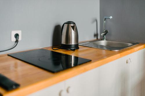 a coffee maker sitting on a counter next to a sink at Апартаменты на Ленина 43 in Voronezh