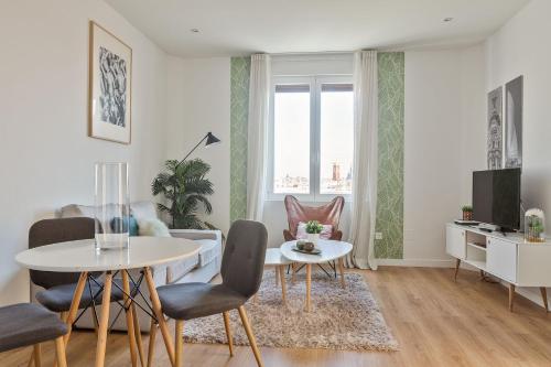 a living room with a table and chairs at Canaan Boutique Apartments Madrid in Madrid