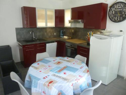 Il comprend une cuisine équipée d'une table et d'un réfrigérateur. dans l'établissement Gite de la plage, à Mers-les-Bains