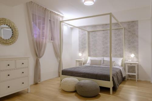 una camera con letto a baldacchino e specchio di Bologna House Tubertini Apartment a Bologna