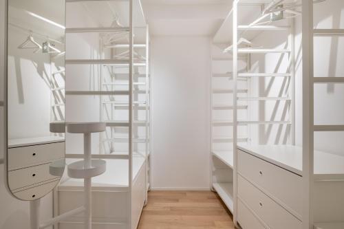una cabina armadio con armadi bianchi e specchio di Bologna House Tubertini Apartment a Bologna
