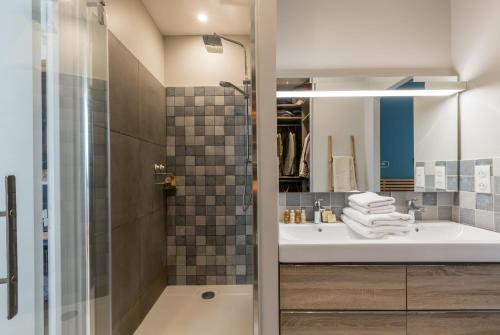une salle de bain avec un lavabo et une douche dans l'établissement Veeve - The Library Wall, à Paris