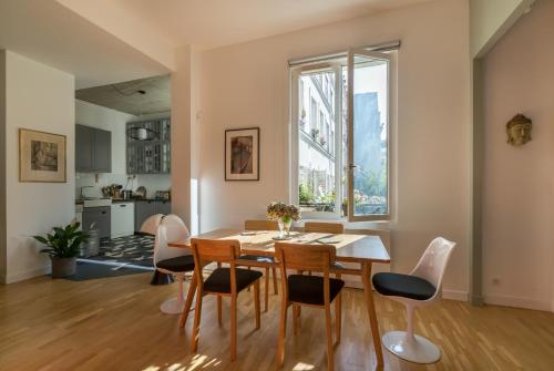 une salle à manger avec une table et des chaises et une fenêtre dans l'établissement Veeve - The Library Wall, à Paris