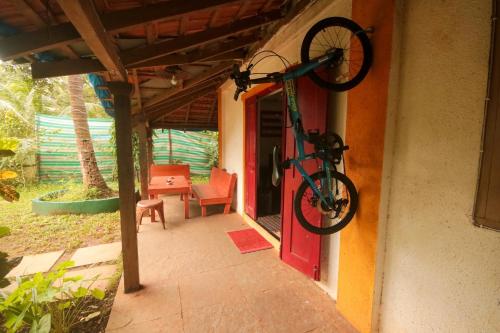 a bike hanging on the side of a house at Red Door Hostel Anjuna in Anjuna