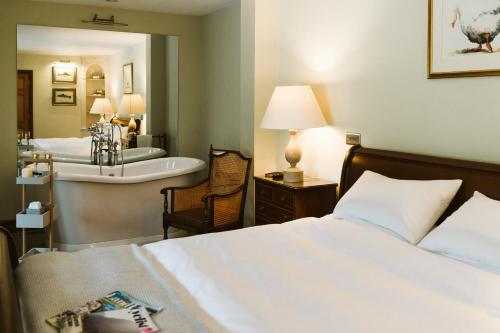 a bedroom with a bed and a bathroom with a sink at The Apple Rooms - Houghton Lodge in Stockbridge