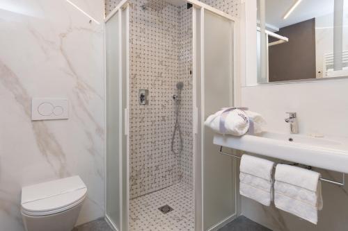a bathroom with a shower and a toilet and a sink at UNAHOTELS Ala Venezia-Adults 16 in Venice