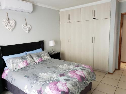 a bedroom with a bed and white cabinets at 11 Villa Del Sol in Amanzimtoti