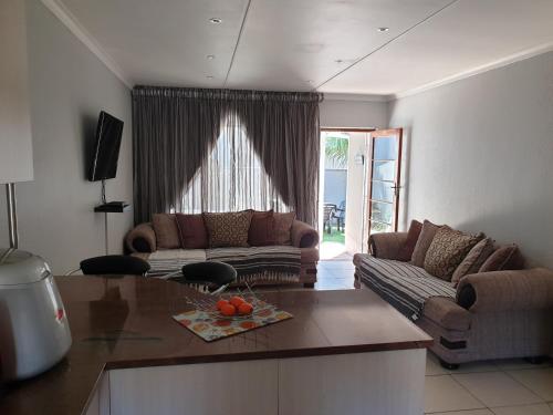 a living room with a couch and a table at 11 Villa Del Sol in Amanzimtoti