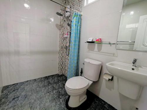 a white bathroom with a toilet and a sink at SER-EN-DIP-I-TY - SHA Extra Plus in Ko Lanta