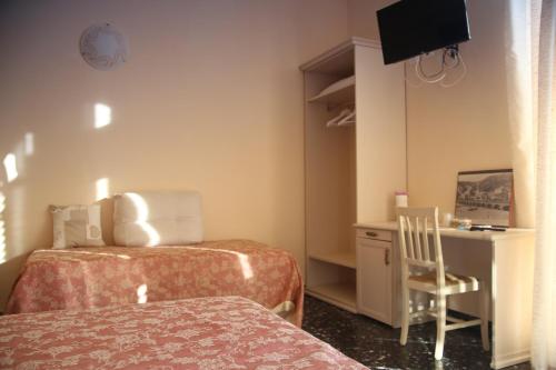 a room with two beds and a desk and a chair at Vivi 5 terre in La Spezia
