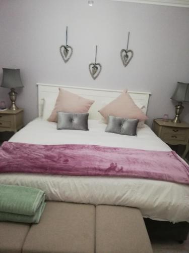 a bedroom with a large bed with pink and purple sheets at 504 Witsand in Bloubergstrand