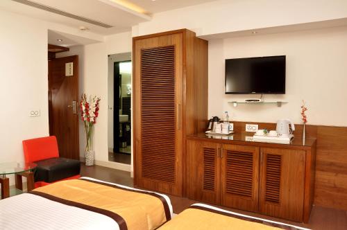 a hotel room with a bed and a flat screen tv at Hotel Niharika in Kolkata