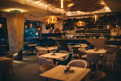 a restaurant with tables and chairs and a bar at Hotel Verso in Mostar