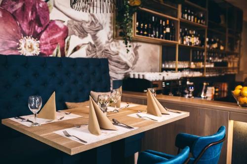 a table in a restaurant with napkins and wine glasses at Hotel Verso in Mostar