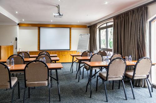 a classroom with tables and chairs and a whiteboard at Island Club Hotel & Apartments in Cape Town
