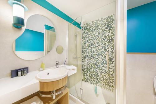 
a bathroom with a sink, mirror, and bathtub at Center Parcs Le Bois aux Daims in Morton
