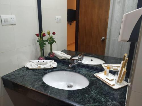 a bathroom counter with a sink and a mirror at La Franklin Hotel in Bhubaneshwar