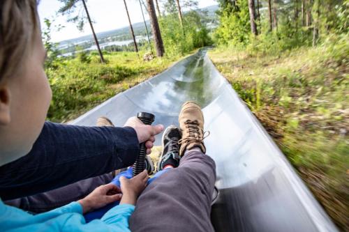 a boy is sitting on a track with his shoes on at Lapland Hotels Ounasvaara Chalets in Rovaniemi