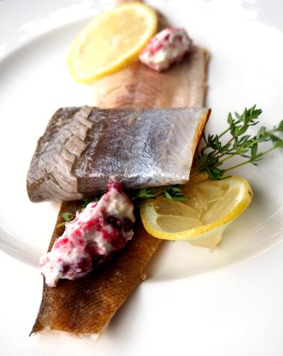 a plate of food with fish and lemon slices at Landhotel Pacher in Obervellach